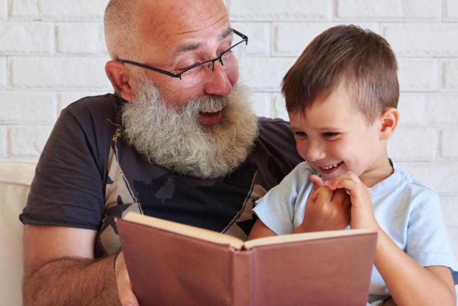 Ein Kitakind und sein Großvater lesen ein Buch