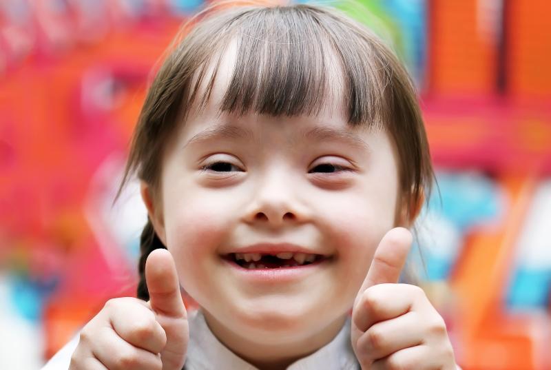 Ein lächelndes Mädchen mit Down-Syndrom